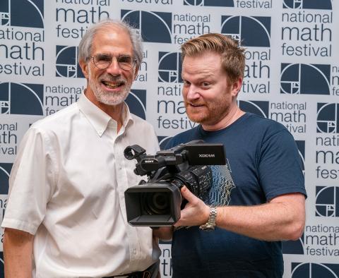 Numberphile's Brady Haran with camera and MSRI's David Eisenbud at National Math Festival 2019