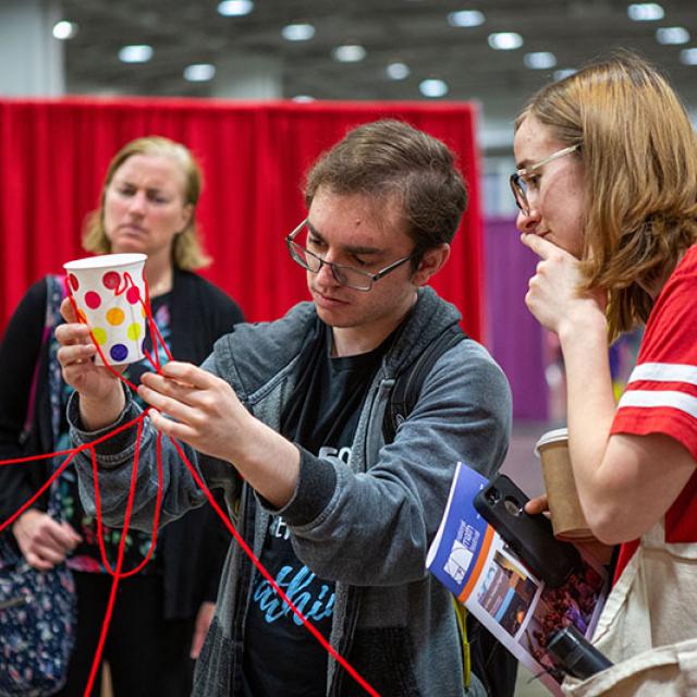 2019 festival attendees inspecting cup with strings attached
