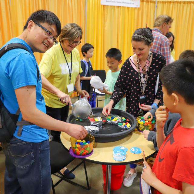 Event attendees smiling and playing with shapes - National Math Festival 2019