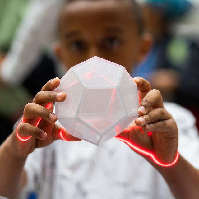 Boy holding geometric block with laser at 2019 festival