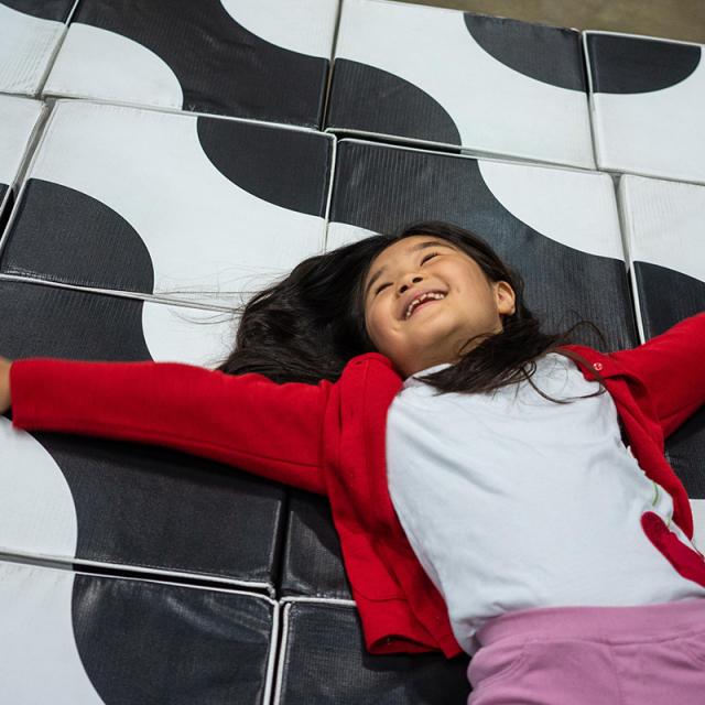 Girl laying on large puzzle blocks at 2019 festival