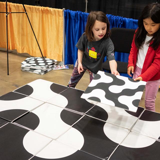 2 girls working on large block puzzle at 2019 festival
